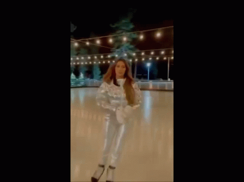 Brunette Celebrity in Silver Outfit Skating on Ice picture 1 of 1