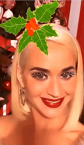 Blonde Celebrity Smiling with Red Lipstick and Christmas Tree Decoration'